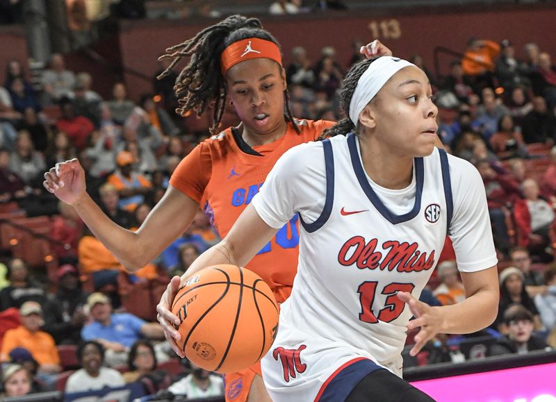 March 8, 2024; Greenville, S.C.; Ole Miss guard Mariyah Noel (13) dribbles by Florida guard Jeriah Warren (20) during the first quarter of the SEC Women's Basketball Tournament game at the Bon Secours Wellness Arena in Greenville, S.C. Friday, March 8, 2024. . Mandatory Credit: Ken Ruinard -USA TODAY NETWORK