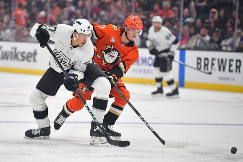 Nov 29, 2024; Anaheim, California, USA; Los Angeles Kings left wing Andre Lee (47) plays for the puck against Anaheim Ducks center Trevor Zegras (11) during the first period at Honda Center. Mandatory Credit: Gary A. Vasquez-Imagn Images