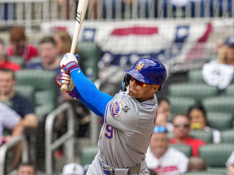 Apr 11, 2024; Cumberland, Georgia, USA; New York Mets left fielder Brandon Nimmo (9) hits a triple to drive in a run against the Atlanta Braves during the eighth inning at Truist Park. Mandatory Credit: Dale Zanine-USA TODAY Sports