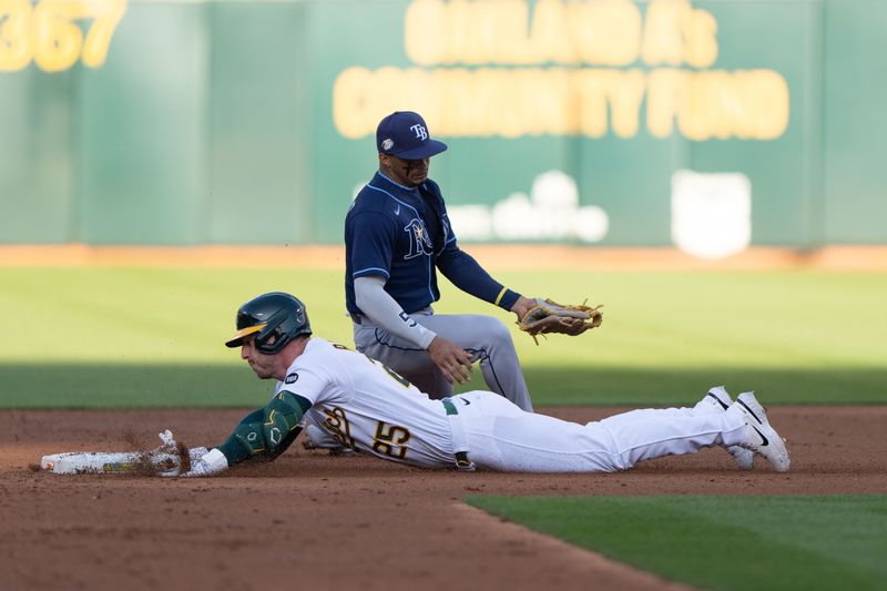 Jun 14, 2023; Oakland, California, USA;  Oakland Athletics left fielder Brent Rooker (25) slides into second base safely during the second inning against Tampa Bay Rays shortstop Wander Franco (5) at Oakland-Alameda County Coliseum. Mandatory Credit: Stan Szeto-USA TODAY Sports