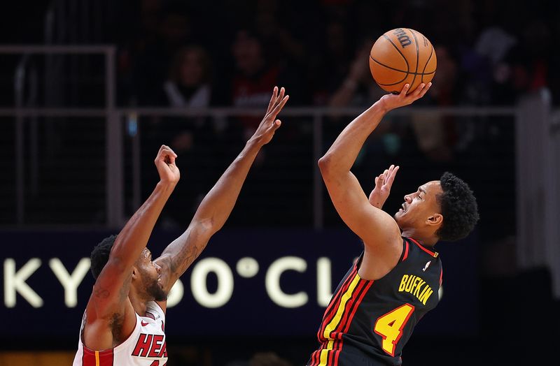 ATLANTA, GEORGIA - APRIL 09:  Kobe Bufkin #4 of the Atlanta Hawks draws a foul as he scores against Haywood Highsmith #24 of the Miami Heat during the second quarter at State Farm Arena on April 09, 2024 in Atlanta, Georgia.  NOTE TO USER: User expressly acknowledges and agrees that, by downloading and/or using this photograph, user is consenting to the terms and conditions of the Getty Images License Agreement.  (Photo by Kevin C. Cox/Getty Images)