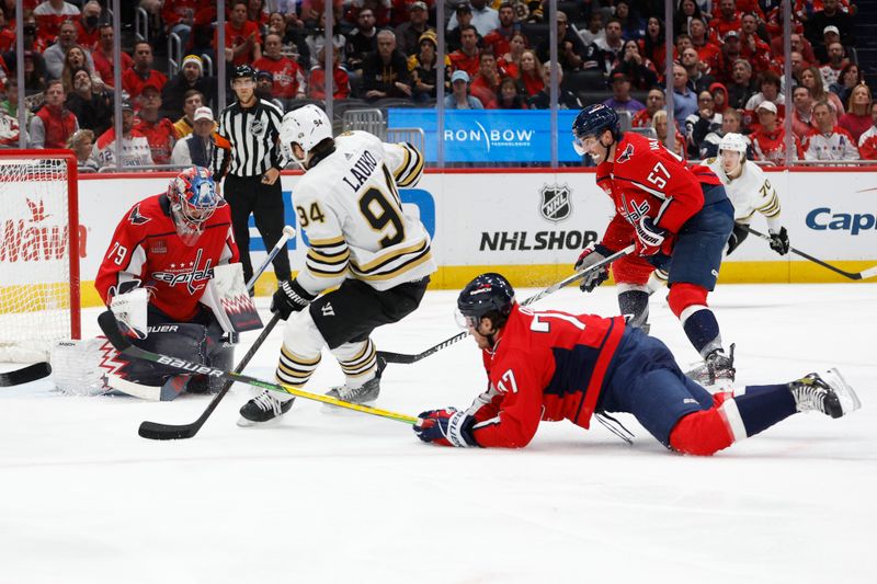 Apr 15, 2024; Washington, District of Columbia, USA; Washington Capitals goaltender Charlie Lindgren (79) makes a save on Boston Bruins center Jakub Lauko (94) as Capitals defenseman John Carlson (74) defends in the second period at Capital One Arena. Mandatory Credit: Geoff Burke-USA TODAY Sports