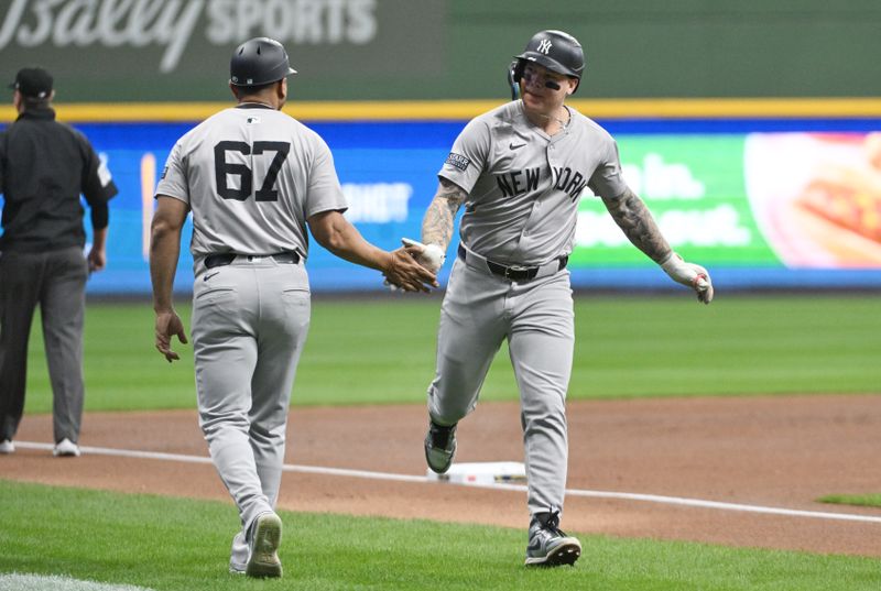 Apr 27, 2024; Milwaukee, Wisconsin, USA; Milwaukee Brewers catcher William Contreras (24) is congratulated by New York Yankees third base coach Luis Rojas (67) after hitting a home run against the Milwaukee Brewers in the first inning at American Family Field. Mandatory Credit: Michael McLoone-USA TODAY Sports