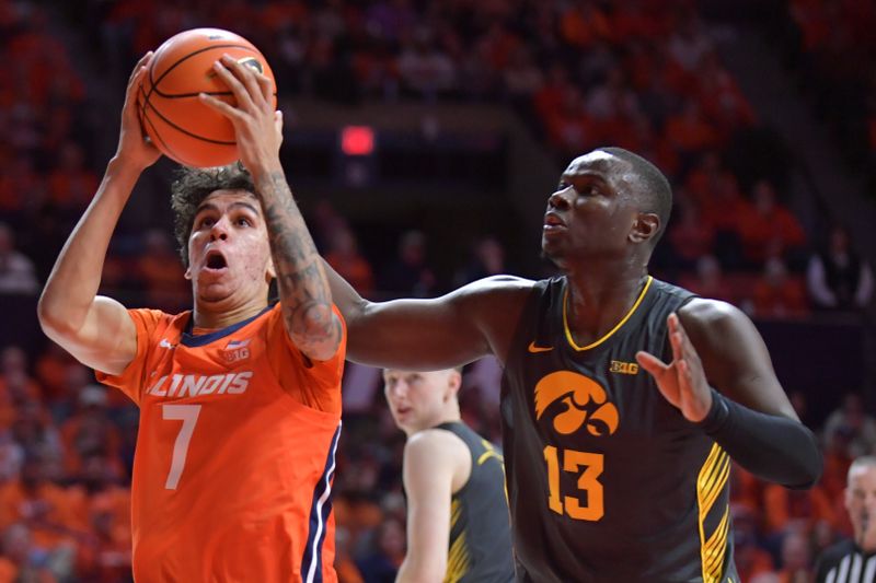 Feb 25, 2025; Champaign, Illinois, USA;  Illinois Fighting Illini forward Will Riley (7) drives to the basket as Iowa Hawkeyes forward Ladji Dembele (13) defends  during the first half at State Farm Center. Mandatory Credit: Ron Johnson-Imagn Images