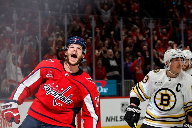 Apr 15, 2024; Washington, District of Columbia, USA; Washington Capitals center Nic Dowd (26) celebrates after scoring an empty net goal as Boston Bruins left wing Brad Marchand (63) looks on in the final minute of the third period at Capital One Arena. Mandatory Credit: Geoff Burke-USA TODAY Sports