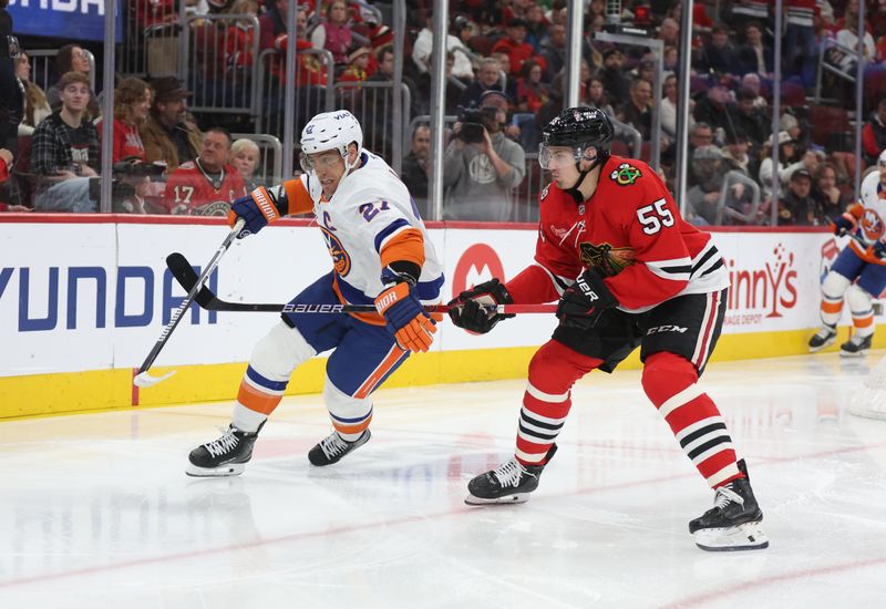 Dec 30, 2025; Chicago, Illinois, USA; New York Islanders left wing Anders Lee (27) and Chicago Blackhawks defenseman Artyom Levshunov (55) battle for control of the puck during the second period  at United Center. Mandatory Credit: Talia Sprague-Imagn Images