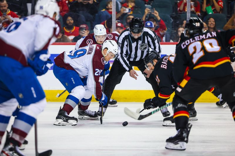 Mar 12, 2024; Calgary, Alberta, CAN; Colorado Avalanche center Nathan MacKinnon (29) and Calgary Flames center Mikael Backlund (11) face off for the puck during the second period at Scotiabank Saddledome. Mandatory Credit: Sergei Belski-USA TODAY Sports