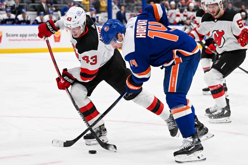 Mar 24, 2024; Elmont, New York, USA;  New York Islanders center Bo Horvat (14) and New Jersey Devils defenseman Luke Hughes (43) battle for the puck during the second period at UBS Arena. Mandatory Credit: Dennis Schneidler-USA TODAY Sports