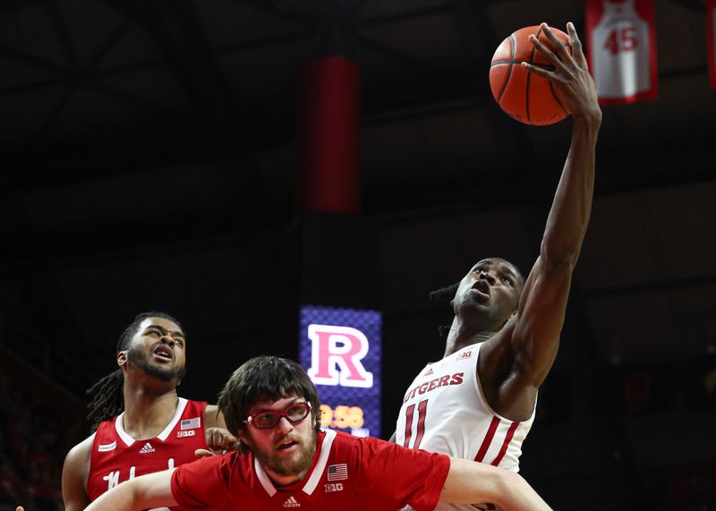 Feb 14, 2023; Piscataway, New Jersey, USA; Rutgers Scarlet Knights center Clifford Omoruyi (11) rebounds against Nebraska Cornhuskers forward Wilhelm Breidenbach (32) and forward Derrick Walker (13) during the second half at Jersey Mike's Arena. Mandatory Credit: Vincent Carchietta-USA TODAY Sports