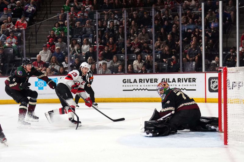 Mar 16, 2024; Tempe, Arizona, USA; New Jersey Devils center Nico Hischier (13) hits the crossbar against Arizona Coyotes goaltender Karel Vejmelka (70) during the third period at Mullett Arena. Mandatory Credit: Joe Camporeale-USA TODAY Sports