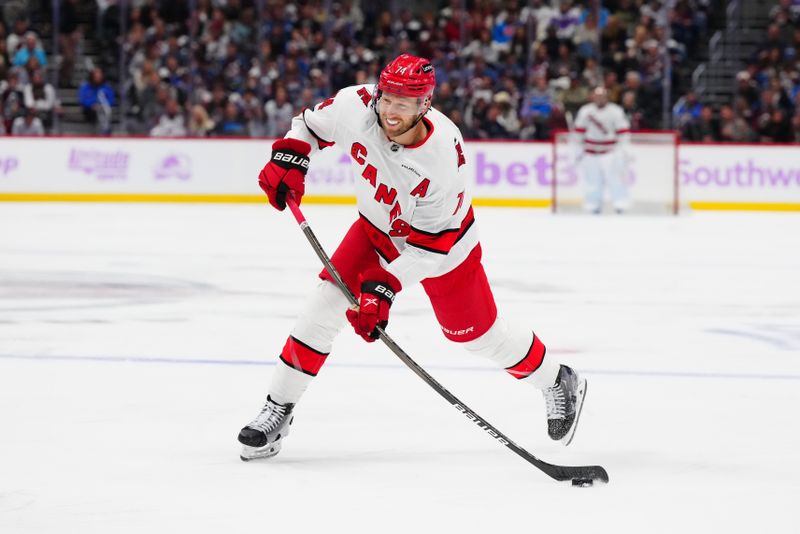 Nov 9, 2024; Denver, Colorado, USA; Carolina Hurricanes defenseman Jaccob Slavin (74) shoots the puck in the first period against the Colorado Avalanche at Ball Arena. Mandatory Credit: Ron Chenoy-Imagn Images