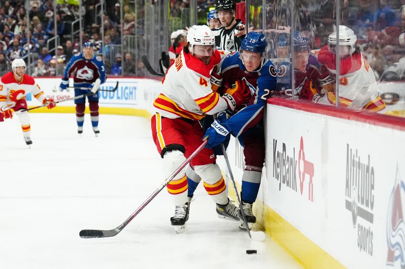 Dec 11, 2023; Denver, Colorado, USA; Calgary Flames defenseman Rasmus Andersson (4) checks Colorado Avalanche left wing Fredrik Olofsson (22) in the second period at Ball Arena. Mandatory Credit: Ron Chenoy-USA TODAY Sports