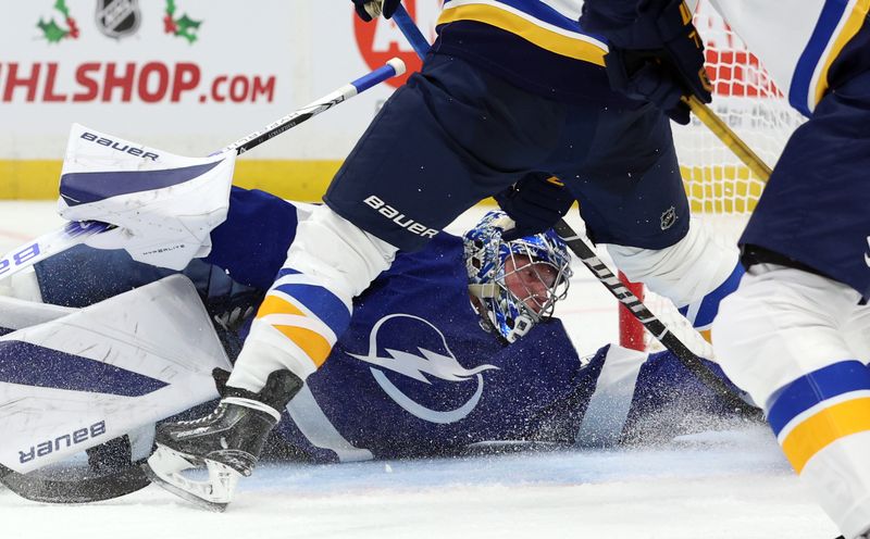 Dec 19, 2023; Tampa, Florida, USA; Tampa Bay Lightning goaltender Andrei Vasilevskiy (88) makes a save against St. Louis Blues defenseman Justin Faulk (72) during the second period at Amalie Arena. Mandatory Credit: Kim Klement Neitzel-USA TODAY Sports