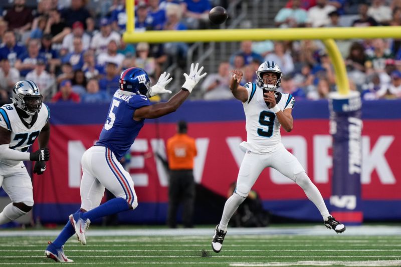 Carolina Panthers quarterback Bryce Young, right, throws past New York Giants' Kayvon Thibodeaux during the first half of an NFL preseason football game, Friday, Aug. 18, 2023, in East Rutherford, N.J. (AP Photo/Bryan Woolston)