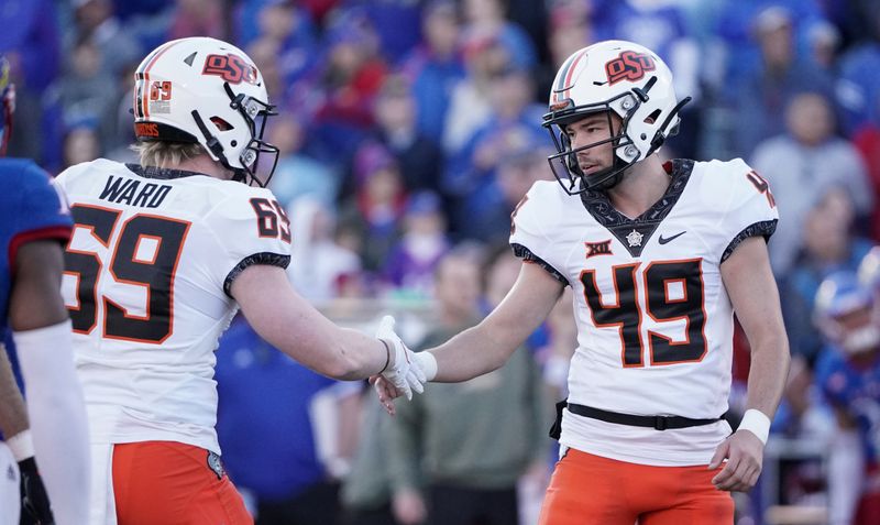 Nov 5, 2022; Lawrence, Kansas, USA; Oklahoma State Cowboys place kicker Tanner Brown (49) celebrates with offensive lineman Evan Bax (69) after kicking a field goal against the Kansas Jayhawks during the second half of the game at David Booth Kansas Memorial Stadium. Mandatory Credit: Denny Medley-USA TODAY Sports