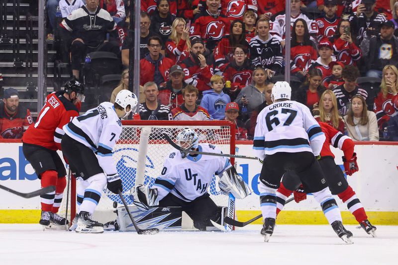 Oct 14, 2024; Newark, New Jersey, USA; New Jersey Devils center Nico Hischier (13) scores a goal on Utah Hockey Club goaltender Karel Vejmelka (70) during the third period at Prudential Center. Mandatory Credit: Ed Mulholland-Imagn Images