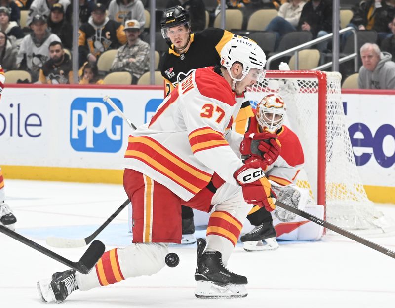 Jan 10, 2026; Pittsburgh, Pennsylvania, USA; Calgary Flames defenseman Yan Kuznetsov (37) blocks a shot by Pittsburgh Penguins right wing  Rickard Rakell (67) and goalie Devin Cooley (1) during the third period at PPG Paints Arena. Mandatory Credit: Philip G. Pavely-Imagn Images
