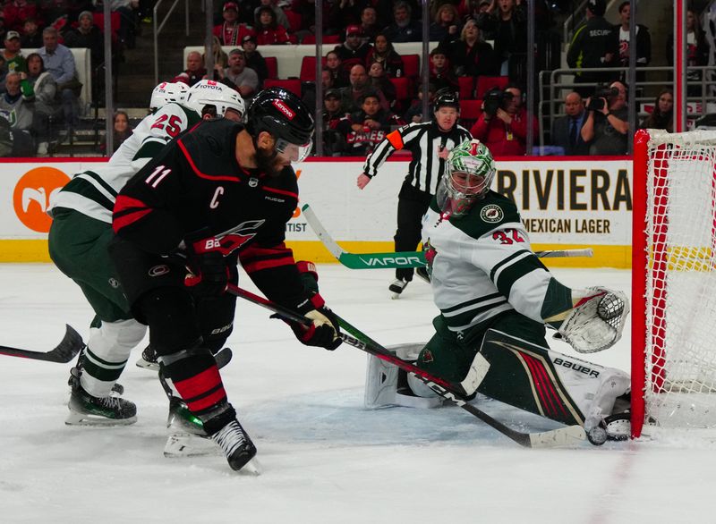 Jan 21, 2024; Raleigh, North Carolina, USA;  Minnesota Wild goaltender Filip Gustavsson (32) stops the shot by Carolina Hurricanes center Jordan Staal (11) during the third period at PNC Arena. Mandatory Credit: James Guillory-USA TODAY Sports