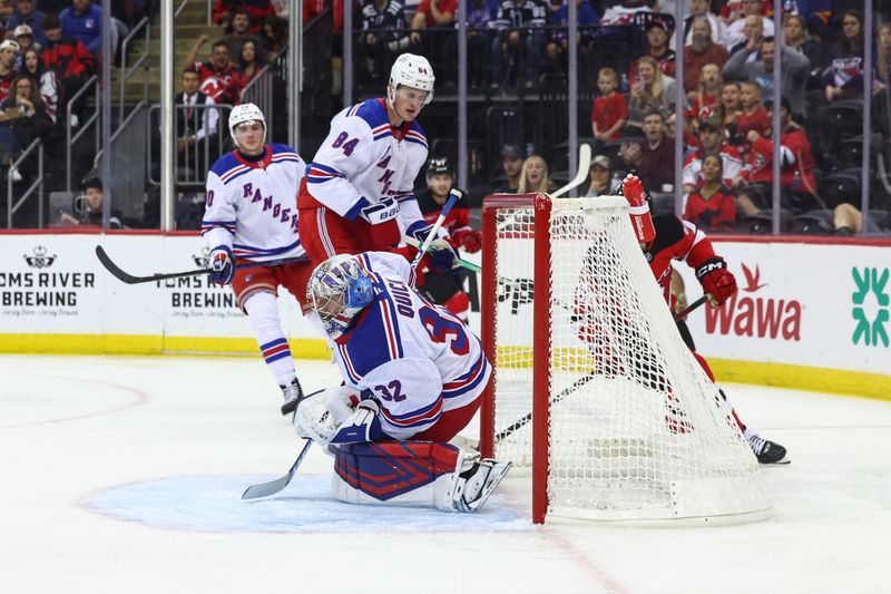 Sep 30, 2024; Newark, New Jersey, USA; New York Rangers goaltender Jonathan Quick (32) makes a save against the New Jersey Devils during the second period at Prudential Center. Mandatory Credit: Ed Mulholland-Imagn Images