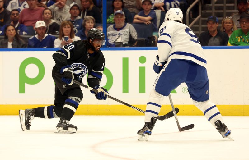 Apr 17, 2024; Tampa, Florida, USA; Tampa Bay Lightning left wing Anthony Duclair (10) shoots as Toronto Maple Leafs center John Tavares (91) defends during the first period at Amalie Arena. Mandatory Credit: Kim Klement Neitzel-USA TODAY Sports