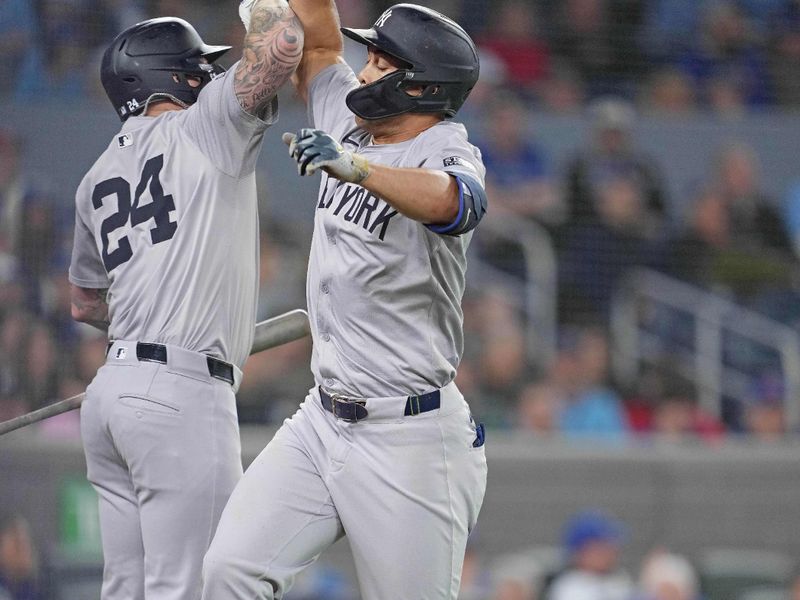 Apr 17, 2024; Toronto, Ontario, CAN; New York Yankees designated hitter Giancarlo Stanton (27) hits a home run and celebrates with left fielder Alex Verdugo (24) against the Toronto Blue Jays during the ninth inning at Rogers Centre. Mandatory Credit: Nick Turchiaro-USA TODAY Sports