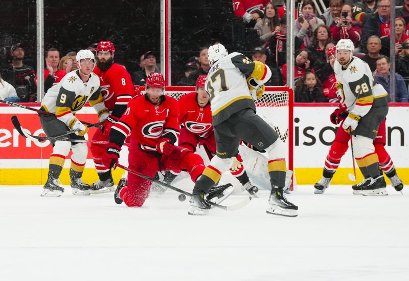 Jan 17, 2025; Raleigh, North Carolina, USA; Carolina Hurricanes center Jordan Staal (11) blocks the shot by Vegas Golden Knights defenseman Shea Theodore (27) during the third period at Lenovo Center. Mandatory Credit: James Guillory-Imagn Images