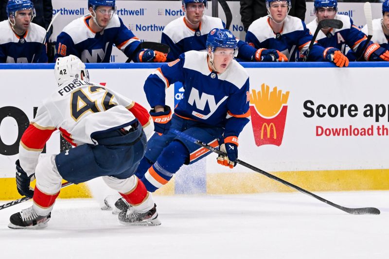 Jan 27, 2024; Elmont, New York, USA; New York Islanders right wing Simon Holmstrom (10) skates with the puck defended by Florida Panthers defenseman Gustav Forsling (42) during the second period at UBS Arena. Mandatory Credit: Dennis Schneidler-USA TODAY Sports