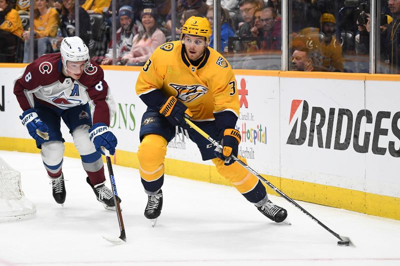 Mar 2, 2024; Nashville, Tennessee, USA; Nashville Predators defenseman Jeremy Lauzon (3) skates with the puck against Colorado Avalanche defenseman Cale Makar (8) during the first period at Bridgestone Arena. Mandatory Credit: Christopher Hanewinckel-USA TODAY Sports