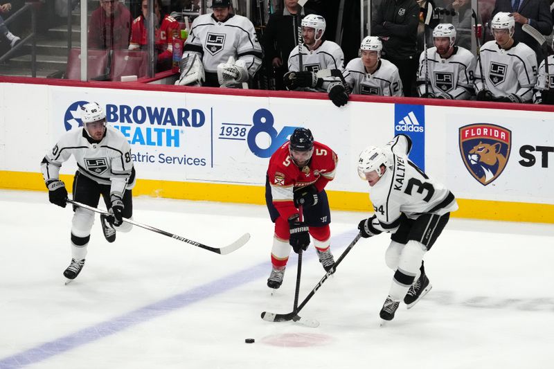 Jan 11, 2024; Sunrise, Florida, USA; Los Angeles Kings right wing Arthur Kaliyev (34) and Florida Panthers defenseman Aaron Ekblad (5) battle for the puck during the third period at Amerant Bank Arena. Mandatory Credit: Jasen Vinlove-USA TODAY Sports