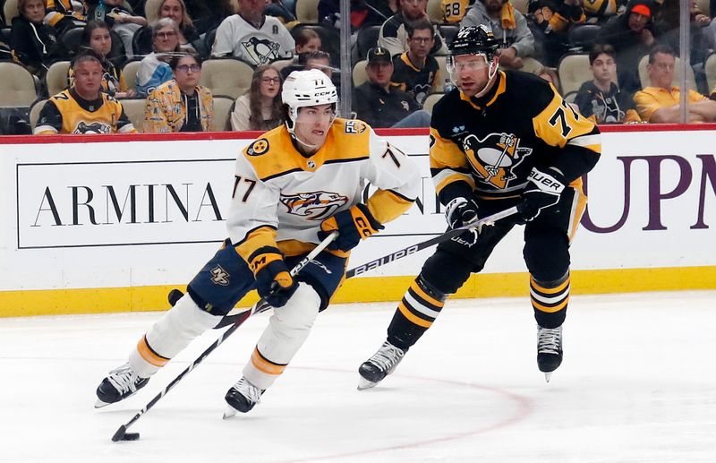 Apr 15, 2024; Pittsburgh, Pennsylvania, USA;  Nashville Predators right wing Luke Evangelista (77) moves the puck against Pittsburgh Penguins center Jeff Carter (right) during the third period at PPG Paints Arena. The Penguins won 4-2. Mandatory Credit: Charles LeClaire-USA TODAY Sports