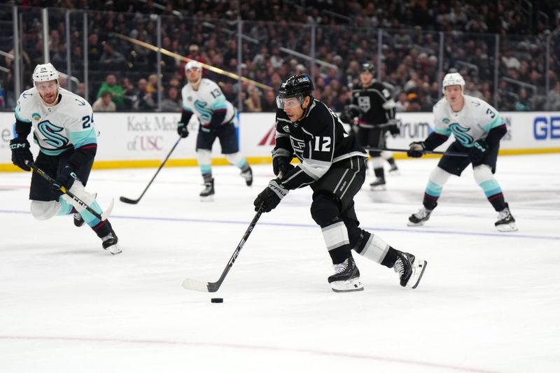 Dec 20, 2023; Los Angeles, California, USA; LA Kings left wing Trevor Moore (12) skates with the puck against the Seattle Kraken in the second period at Crypto.com Arena. Mandatory Credit: Kirby Lee-USA TODAY Sports