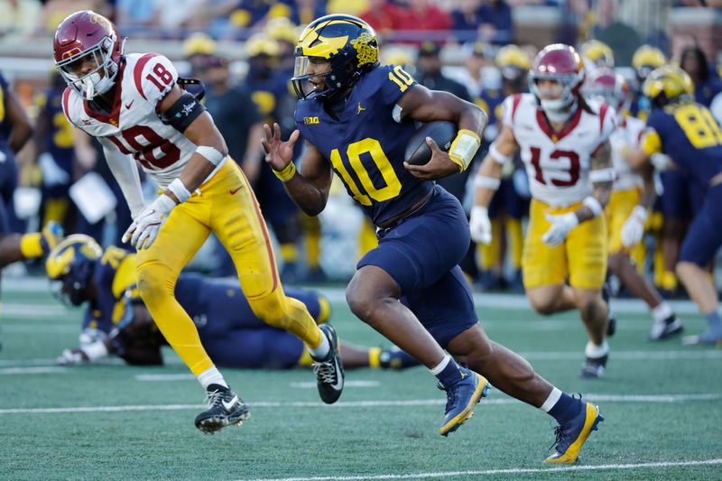 Sep 21, 2024; Ann Arbor, Michigan, USA;  Michigan Wolverines quarterback Alex Orji (10) runs in the second half against the USC Trojans at Michigan Stadium. Mandatory Credit: Rick Osentoski-Imagn Images