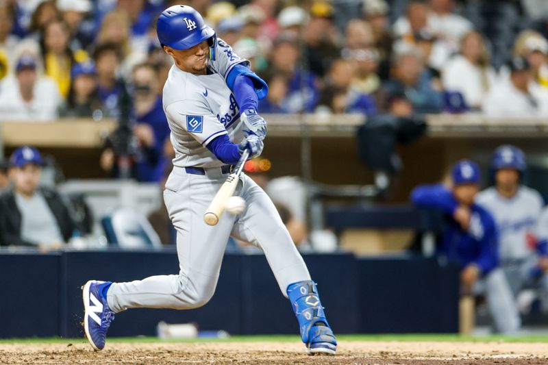 Jun 9, 2025; San Diego, California, USA; Los Angeles Dodgers second baseman Tommy Edman (25) hits an RBI single during the tenth inning against the San Diego Padres at Petco Park. Mandatory Credit: David Frerker-Imagn Images
