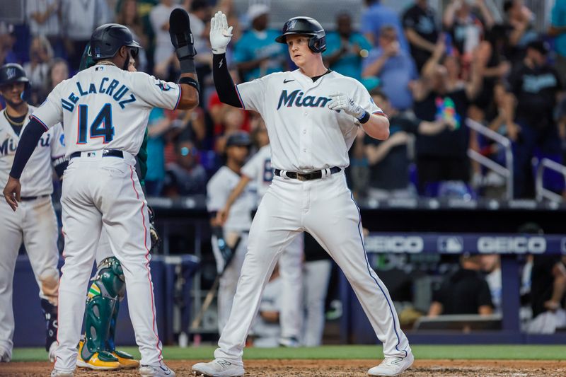 Jun 4, 2023; Miami, Florida, USA; Miami Marlins designated hitter Garrett Cooper (26) celebrates with left fielder Bryan De La Cruz (14) after hitting a three-run home run against the Oakland Athletics during the fifth inning at loanDepot Park. Mandatory Credit: Sam Navarro-USA TODAY Sports