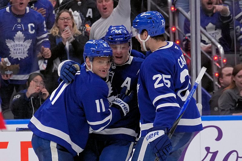 Apr 20, 2025; Toronto, Ontario, CAN; Toronto Maple Leafs forward Max Domi (11) and defenceman Brandon Carlo (25) congratulate defenceman Morgan Rielly (44) on his goal against the Ottawa Senators during the third period of game one of the first round of the 2025 Stanley Cup Playoffs at Scotiabank Arena. Mandatory Credit: John E. Sokolowski-Imagn Images