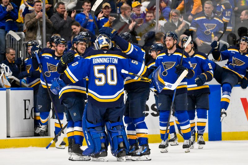 Nov 21, 2024; St. Louis, Missouri, USA;  St. Louis Blues goaltender Jordan Binnington (50) is congratulated by teammates after saving all three shootout shots in a victory over the San Jose Sharks at Enterprise Center. Mandatory Credit: Jeff Curry-Imagn Images