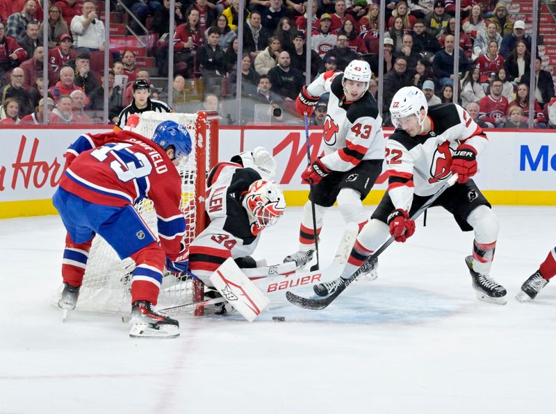 Jan 25, 2025; Montreal, Quebec, CAN; New Jersey Devils goalie Jake Allen (34) and defenseman Luke Hughes (43) and defenseman Brett Pesce (22) stop Montreal Canadiens forward Cole Caufield (13) during the second period at the Bell Centre. Mandatory Credit: Eric Bolte-Imagn Images