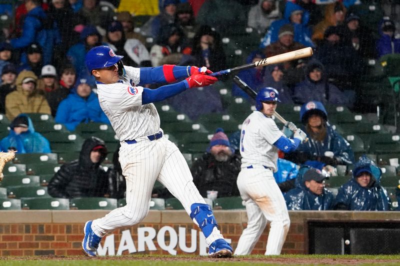 Apr 3, 2024; Chicago, Illinois, USA; Chicago Cubs catcher Miguel Amaya (9) hits a two-run single against the Colorado Rockies during the sixth inning at Wrigley Field. Mandatory Credit: David Banks-USA TODAY Sports