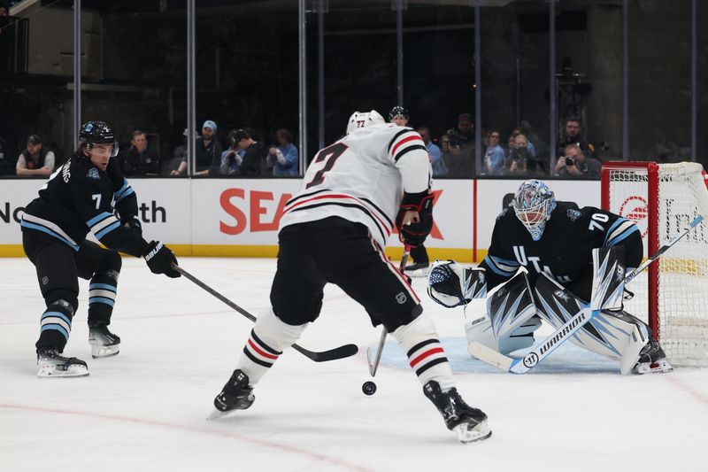 Feb 25, 2025; Salt Lake City, Utah, USA; Chicago Blackhawks left wing Patrick Maroon (77) skates against Utah Hockey Club defenseman Michael Kesselring (7) and goaltender Karel Vejmelka (70) during the second period at Delta Center. Mandatory Credit: Rob Gray-Imagn Images