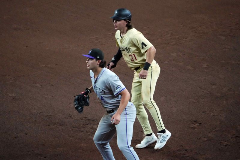 Aug 13, 2024; Phoenix, Arizona, USA; Arizona Diamondbacks outfielder Jake McCarthy (31) leads off first base as Colorado Rockies first base Michael Toglia (4) covers the bag during the fifth inning at Chase Field. Mandatory Credit: Joe Camporeale-USA TODAY Sports