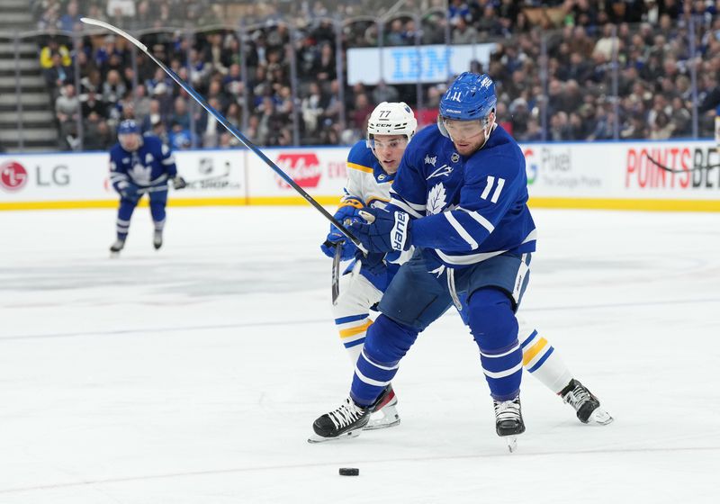 Mar 6, 2024; Toronto, Ontario, CAN; Toronto Maple Leafs center Max Domi (11) battles for the puck with Buffalo Sabres right wing JJ Peterka (77) during the third period at Scotiabank Arena. Mandatory Credit: Nick Turchiaro-USA TODAY Sports