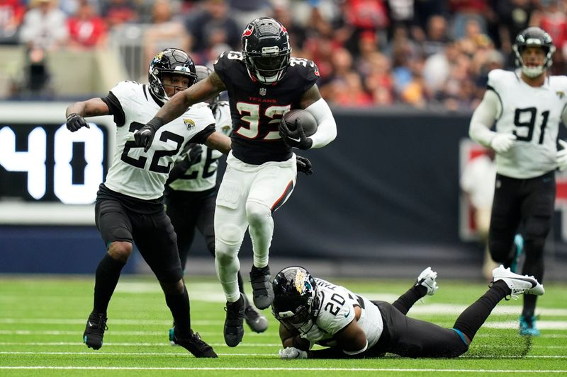 Houston Texans running back Dare Ogunbowale (33) runs from Jacksonville Jaguars safety Daniel Thomas (20) and cornerback Jarrian Jones (22) during the second half of an NFL football game, Sunday, Sept. 29, 2024, in Houston. (AP Photo/Eric Gay)