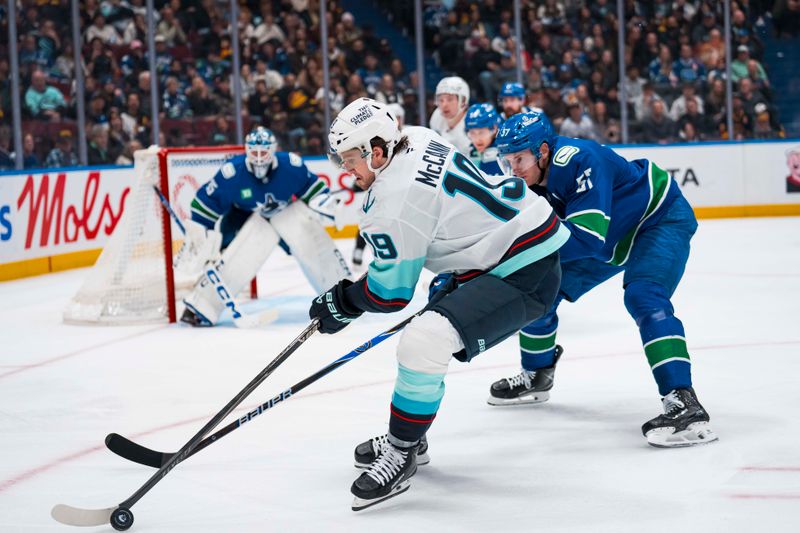 Jan 2, 2026; Vancouver, British Columbia, CAN; Vancouver Canucks defenseman Tyler Myers (57) stick checks Seattle Kraken forward Jared McCann (19) in the third period at Rogers Arena. Mandatory Credit: Bob Frid-Imagn Images