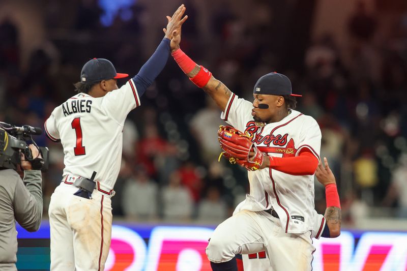 Apr 11, 2023; Atlanta, Georgia, USA; Atlanta Braves second baseman Ozzie Albies (1) and right fielder Ronald Acuna Jr. (13) celebrate a victory against the Cincinnati Reds at Truist Park. Mandatory Credit: Brett Davis-USA TODAY Sports
