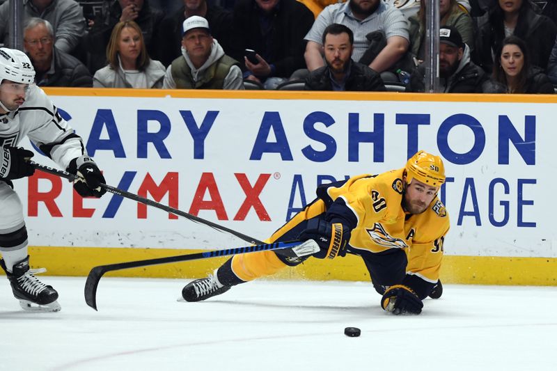 Jan 31, 2024; Nashville, Tennessee, USA; Nashville Predators center Ryan O'Reilly (90) falls as he tries to hit the puck during the third period against the Los Angeles Kings at Bridgestone Arena. Mandatory Credit: Christopher Hanewinckel-USA TODAY Sports