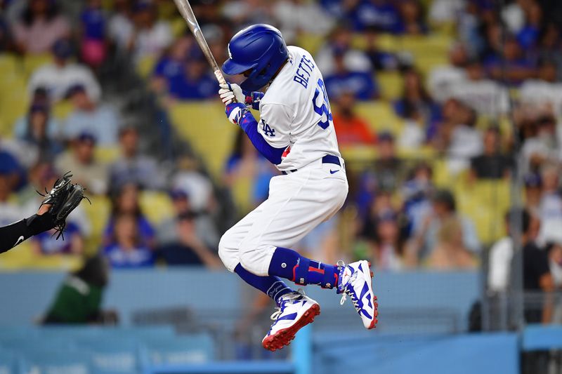 Aug 28, 2023; Los Angeles, California, USA; Los Angeles Dodgers second baseman Mookie Betts (50) leaps to avoid inside pitch from Arizona Diamondbacks relief pitcher Bryce Jarvis (40) during the eighth inning at Dodger Stadium. Mandatory Credit: Gary A. Vasquez-USA TODAY Sports