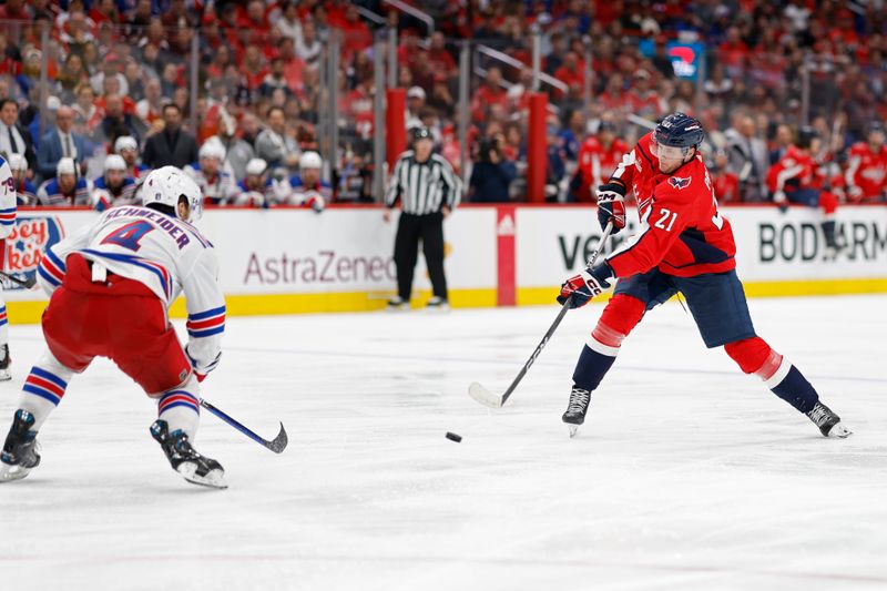 Apr 28, 2024; Washington, District of Columbia, USA; Washington Capitals center Aliaksei Protas (21) shoots the puck as New York Rangers defenseman Braden Schneider (4) defends in the third period in game four of the first round of the 2024 Stanley Cup Playoffs at Capital One Arena. Mandatory Credit: Geoff Burke-USA TODAY Sports