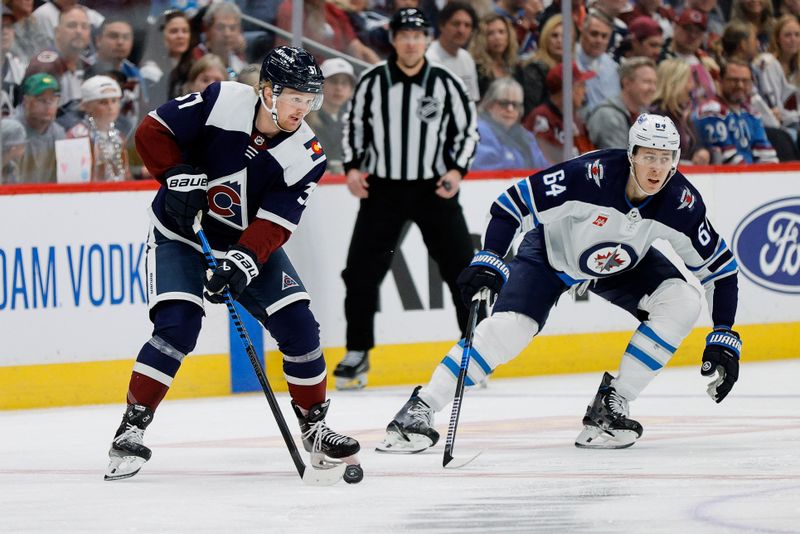 Apr 13, 2024; Denver, Colorado, USA; Colorado Avalanche center Casey Mittelstadt (37) controls the puck as Winnipeg Jets defenseman Logan Stanley (64) defends in the first period at Ball Arena. Mandatory Credit: Isaiah J. Downing-USA TODAY Sports