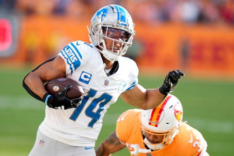 Detroit Lions wide receiver Amon-Ra St. Brown (14) avoids the tackle of Tampa Bay Buccaneers safety Antoine Winfield Jr. (31) on a 27-yard touchdown reception during the first half of an NFL football game Sunday, Oct. 15, 2023, in Tampa, Fla. (AP Photo/Chris O'Meara)