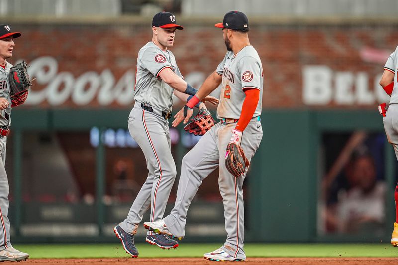 May 29, 2024; Cumberland, Georgia, USA; Washington Nationals right fielder Lane Thomas (28) and second baseman Luis Garcia Jr. (2) react after defeating the Atlanta Braves at Truist Park. Mandatory Credit: Dale Zanine-USA TODAY Sports